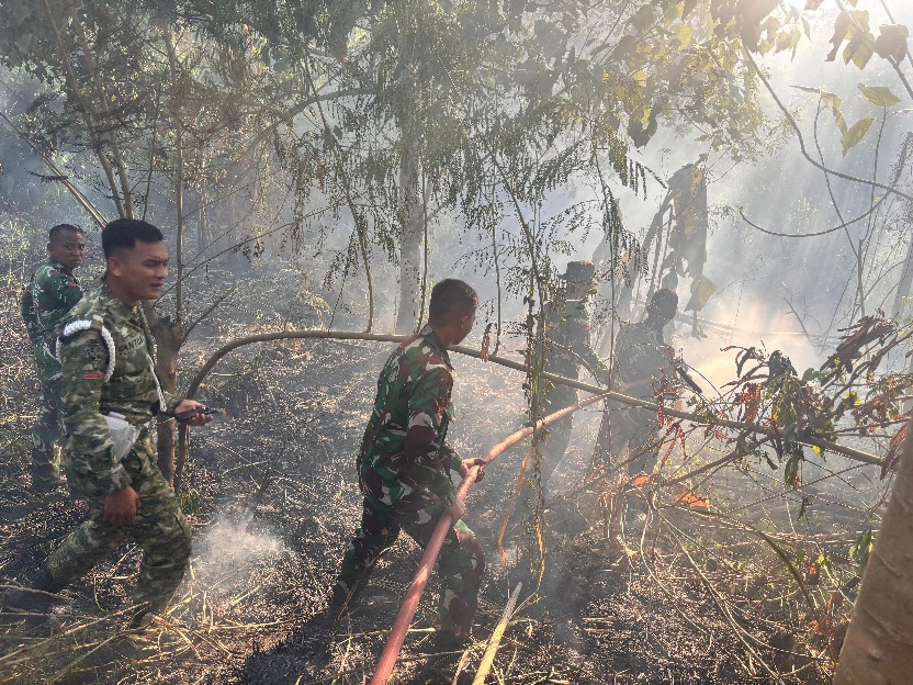 SIGAP: Para prajurit Yonif TP 916/BS saat memadamkan api.